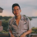 man in brown button up shirt standing near body of water during daytime